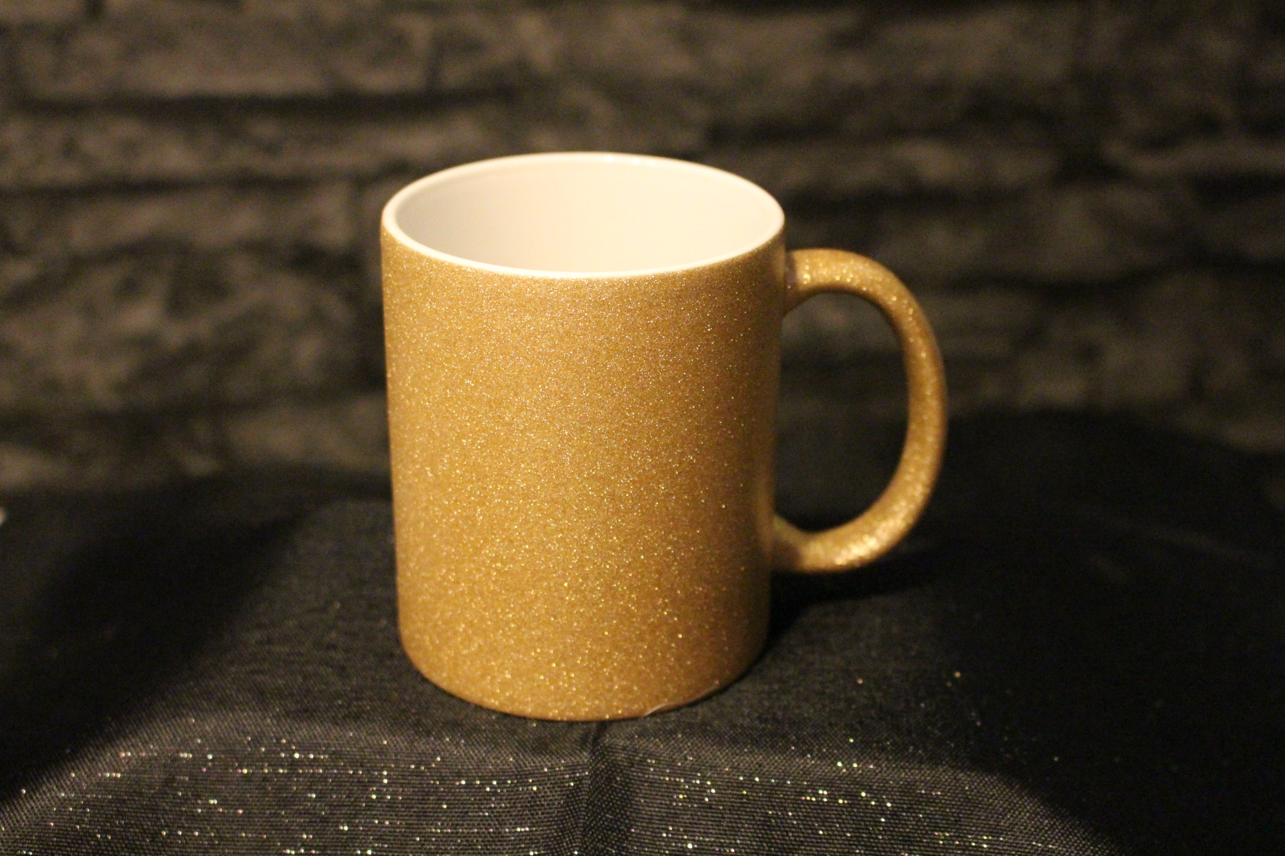 Edle Tasse mit rauer, gold-glitzernder Oberfläche